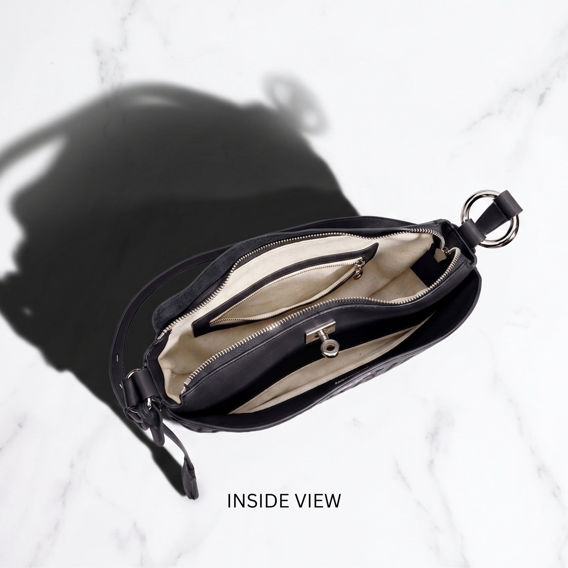 Black handbag with open interior on a white background