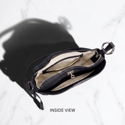 Black handbag with open interior on a white background