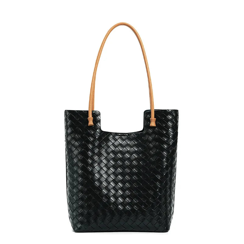 Black woven handbag with tan handle on a white background