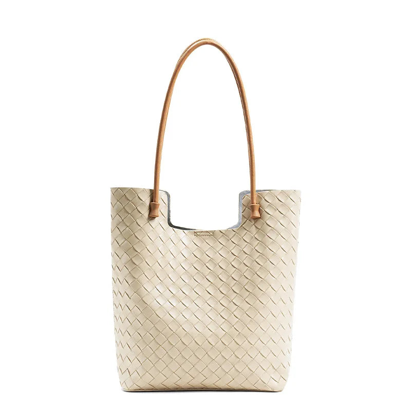 Beige woven handbag with brown handle on a white background